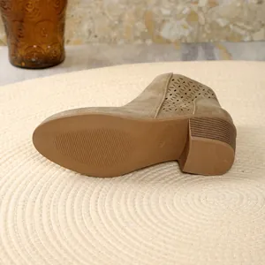 Close-up of tan suede Chelsea boot showing the durable textured sole and block heel