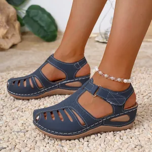 Macro view of blue retro Roman sandals featuring a wedge heel and white stitching.