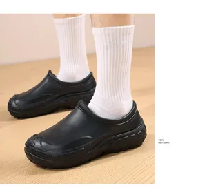 Side view of professional black waterproof and non-slip chef work shoes on wooden floor