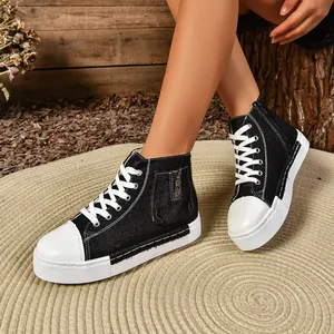 Detailopname van zwarte hoge canvas sneakers voor dames met ritssluiting aan de zijkant en dikke zool