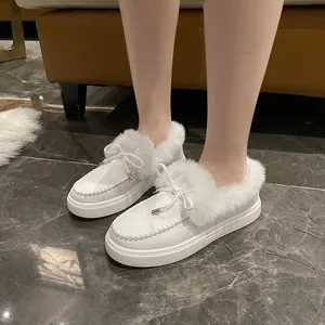 Gros plan de chaussures d'hiver blanches en coton avec fourrure et nœud papillon