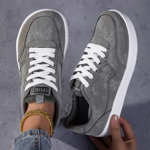 Vue détaillée de baskets décontractées grises rétro japonaises avec lacets blancs.