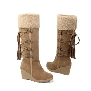 Botas de nieve color camel con cuña, ribete de borreguito y detalle de borlas traseras