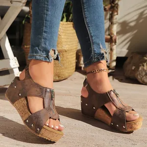 Detail view of stylish brown wedge sandals featuring front zipper and silver rivet accents
