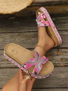 Primer plano de sandalias de plataforma rosas con pedrería boho y suela de corcho