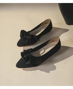 Detail von schwarzen gestrickten Ballerinas mit elegantem Rüschendesign.