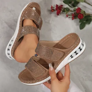 Close-up of brown wedge slippers with rhinestone straps and thick white sole