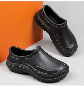 Detailed side view of black waterproof non-slip chef clogs on minimalist orange background