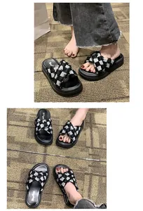 Detailed macro view of black and white checkered cross strap chunky slippers worn by model