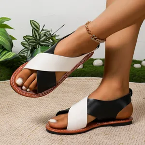 Sandales plates style romain à brides croisées et design bicolore noir et blanc chic