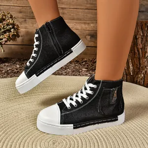 Detailweergave van zwarte hoge canvas sneakers met ritssluiting en een platformzool.