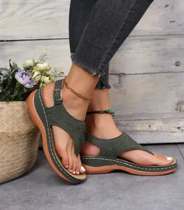 Nahaufnahme grüner Zehentrenner-Sandalen mit Stickerei und bequemer Plateausohle.