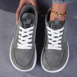 Vue de dessus des baskets décontractées rétro grises avec bout large et lacets blancs