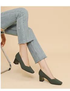 Close-up detail of dark green knitted block heel pumps featuring a square toe and V-cut