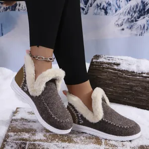 Close-up detail of women's brown warm cotton shoes with white faux fur lining in the snow