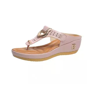 Elegant pink wedge thong sandals for women featuring gold metallic buckle and side logo detail
