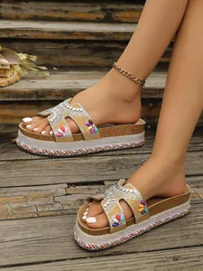 Detalle de sandalias de plataforma bohemias con pedrería y borde de cuerda color
