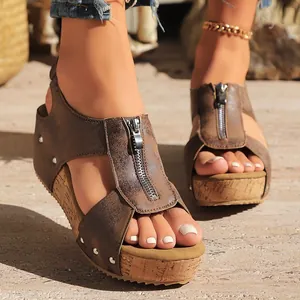 Chic women's brown wedge sandals featuring a stylish front zipper and cork platform detail