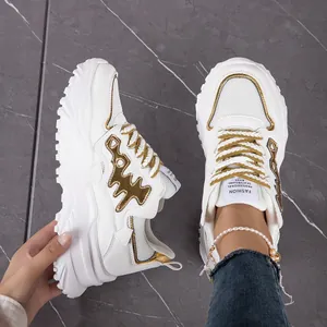 Detailed macro view of stylish white chunky sneakers with gold accents and mesh