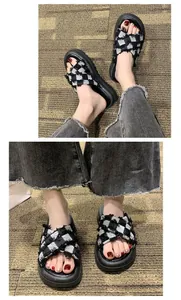 Close-up of women's thick-soled sandals with black and white checkered cross straps