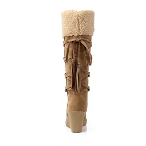 Vista posterior de botas de nieve con cuña y detalle de cordones con borlas