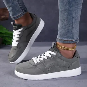 Baskets décontractées grises à bout large avec lacets blancs dans un cadre réel