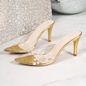 Exquisite detail of gold pointed-toe high heel mules with elegant pearl transparent straps