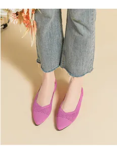 Detailed view of breathable purple knitted pointed flats worn with stylish denim jeans.