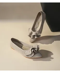 Nahaufnahme von beigen gestrickten Ballerinas mit elegantem Rüschendetail Design.