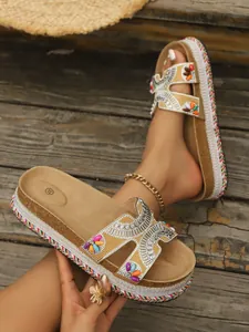Primer plano de sandalias bohemias de plataforma con pedrería brillante y cuentas coloridas
