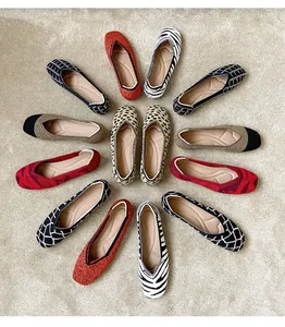 Detailed view of various patterned square toe knit ballet flats on a textured rug