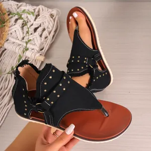 Detailed macro view of women's black canvas studded thong sandals with back zipper detail