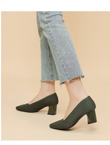 Dark green chunky heel pumps with ribbed texture and square toe worn with jeans