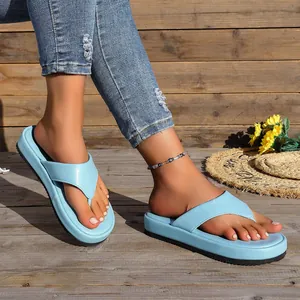 Primer plano de chanclas con plataforma azul claro en un fondo de madera rústica
