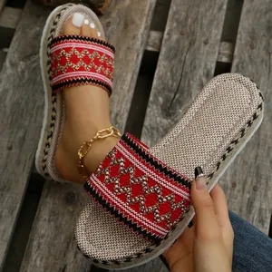 Close-up of ethnic red embroidery and natural woven hemp texture on women platform sandals