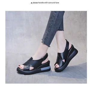 Side view detail of stylish black platform wedge sandals with cross-straps on model