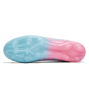 Close-up view of soccer cleat outsole with blue and pink gradient and AG studs for kids