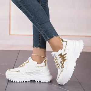 Detail view of stylish white fishbone chunky sneakers for women worn by a model.