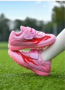 Side view detail of pink breathable mesh kids soccer shoes with red flame patterns