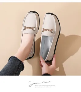 Close-up of beige women's loafers with gold chain detail and soft sole