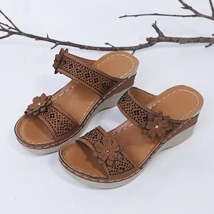 A high-quality detailed view of brown wedge sandals with floral accents and rhinestones