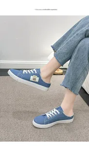 Detalle de zapatillas de mezclilla azul sin espalda con bordes deshilachados y cordones