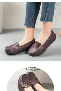 Detailed view of women's brown leather loafers with white contrast stitching and soft sole