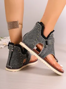 Macro detail view of denim flat thong sandals with studs and back zipper closure
