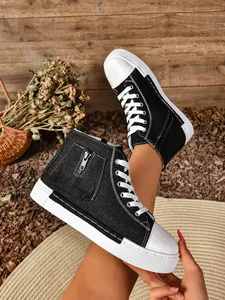Detail van zwarte high-top canvas sneakers met rits en een dikke witte platformzool.