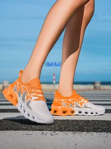 Detailed view of orange and white breathable flyknit running shoes for exercise