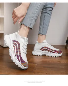 Detailed view of women's white knit sneakers with colorful side stripes and EVA soles