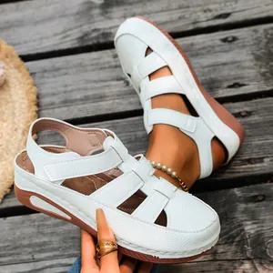 Detailansicht der weißen Keilsandalen aus Kunstleder mit geschlossener Spitze und Design