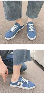 Detalle de las zapatillas mule de denim azul con cordones blancos