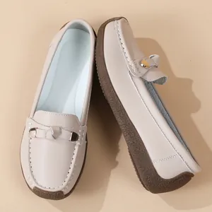 Close-up view of beige soft-sole loafers with metal buckle and anti-slip rubber outsole